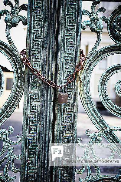 Lock and chain on a old bronze gate.