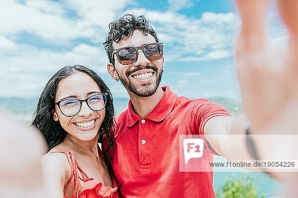 Glückliches junges Paar im Urlaub  das ein Selfie am Strand macht. Lächelndes junges Paar nimmt ein Selbstporträt in der Bucht von San Juan del Sur auf