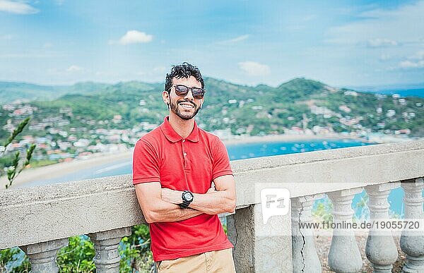 Porträt eines lächelnden Touristen an einem Aussichtspunkt auf eine Bucht. Gutaussehender Tourist mit Blick auf die Bucht von San Juan del Sur