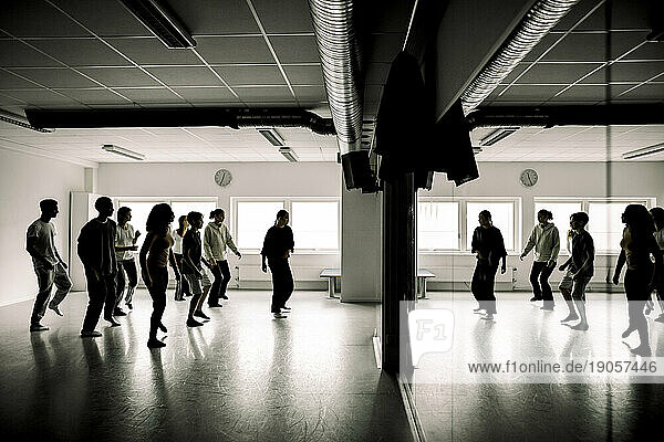 Teenager proben mit einer Lehrerin im Tanzstudio einer High School
