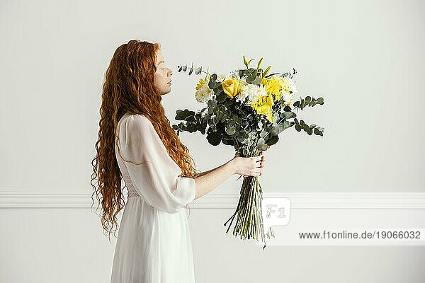 Seitenansicht Frau posiert mit schönen Strauß Frühlingsblumen