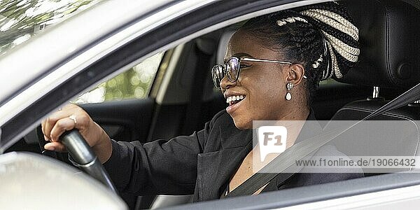 Seitenansicht einer glücklichen Frau  die ihr eigenes Auto fährt