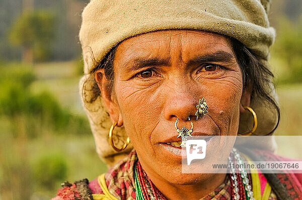 Dolpo  Nepal  ca. Mai 2012: Einheimische Frau mit braunem Kopftuch  großen Ohrringen und Piercings in der Nase und braunen Augen in Dolpo  Nepal. Dokumentarischer Leitartikel  Asien