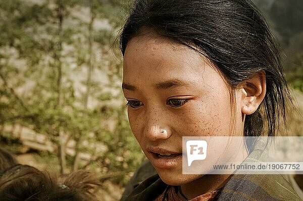 Dolpo  Nepal  etwa im Mai 2012: Ein junges schwarzhaariges Mädchen mit braunen Augen blickt zu Boden und spricht in Dolpo  Nepal. Dokumentarischer Leitartikel  Asien