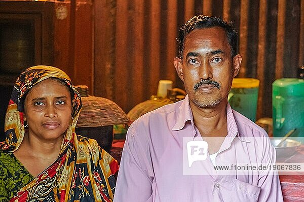 Morolgang  Bangladesch  ca. Juli 2012: Schwarzhaariger Mann mit Schnurrbart in rosa Hemd mit seiner Frau mit buntem Kopftuch in Morolgang  Bangladesch. Dokumentarischer Leitartikel  Asien
