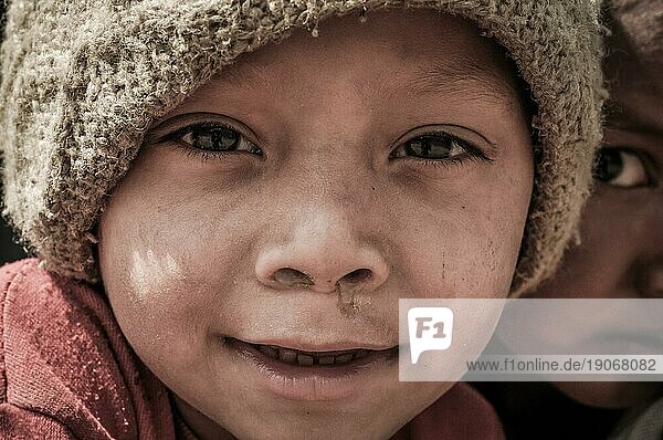 Beni  Nepal  ca. Mai 2012: Junge mit braunen Augen und brauner Mütze auf dem Kopf lächelt freundlich in die Fotokamera in den Straßen von Beni  Nepal. Dokumentarischer Leitartikel  Asien
