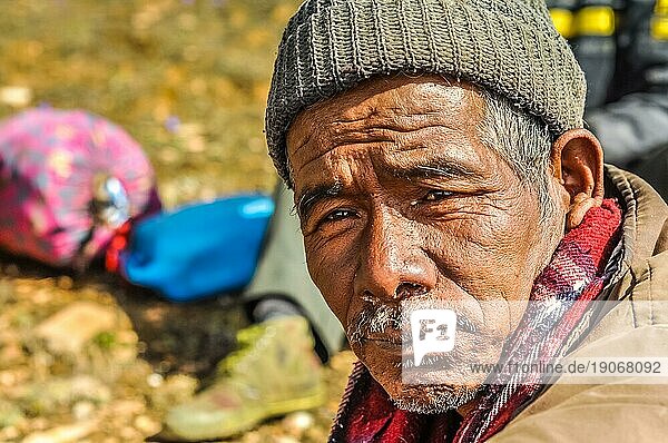 Dolpo  Nepal  ca. Juni 2012: Einheimischer Mann mit grauem Schnurrbart trägt braune Jacke und braune Strickmütze mit interessanten braunen Augen in Dolpo  Nepal. Dokumentarischer Leitartikel  Asien