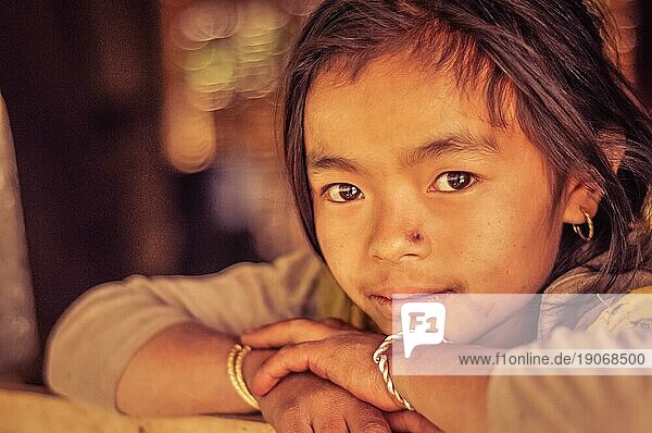 Kanchenjunga Trek  Nepal  etwa im April 2012: Junges Mädchen mit braunen Augen und kleiner Narbe auf der Nase  den Kopf auf die Hände gestützt  beim Kanchenjunga Trek  Nepal. Dokumentarischer Leitartikel  Asien