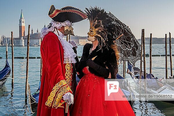 Karnevalsmasken an der Wasserfront mit der Insel San Giorgio zur Zeit vom Karneval  Venedig  Venetien  Norditalien  Italien. UNESCO-Weltkulturerbe