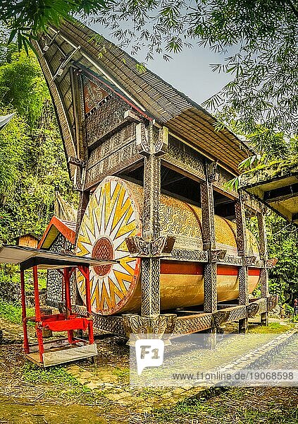 Foto eines traditionellen Grabes mit farbenfrohen Ornamenten und einem großen bootsförmigen Dach in Kete Kesu  Region Toraja in Sulawesi  Indonesien  Asien