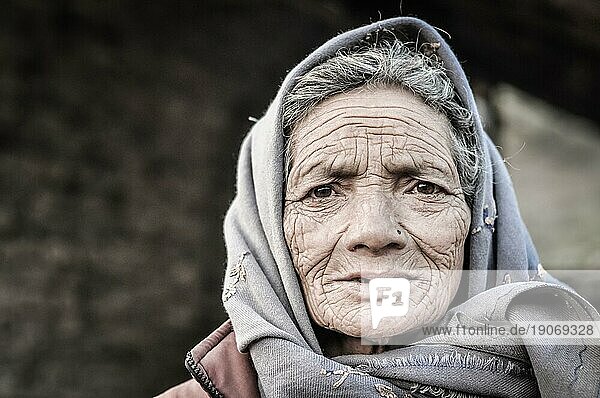Dolpo  Nepal  ca. Mai 2012: Alte Frau mit Falten im Gesicht und braunen Augen trägt ein graues Kopftuch in Dolpo  Nepal. Dokumentarischer Leitartikel  Asien