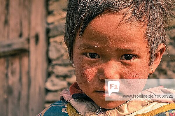 Beni  Nepal  ca. Mai 2012: Ein kleines Mädchen mit kurzen braunen Haaren und braunen Augen trägt Ohrringe und schaut traurig in die Kamera in Beni  Nepal. Dokumentarischer Leitartikel  Asien