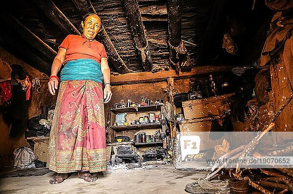 Dolpo  Nepal  ca. Mai 2012: Eine einheimische Frau in orangefarbenem TShirt und langem Rock steht in ihrem Haus und blickt in Dolpo  in die Fotokamera. Dokumentarischer Leitartikel  Asien