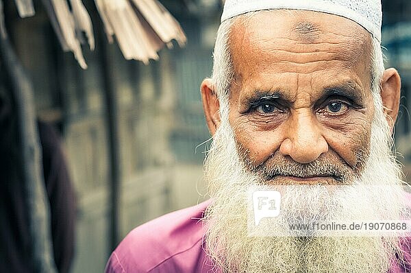 Paigacha  Bangladesch  ca. Juli 2012: Alter Mann mit langem weißen Bart  gekleidet in rosa Hemd und weißer Mütze  mit interessanten braunen und blaün Augen in Paigacha  Bangladesch. Dokumentarischer Leitartikel  Asien