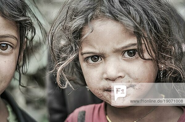 Beni  Nepal  ca. Mai 2012: Junges einheimisches Mädchen mit braunen Haaren und großen braunen Augen hat Schmutz um den Mund und blickt stirnrunzelnd in die Kamera in Beni  Nepal. Dokumentarischer Leitartikel  Asien