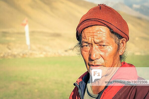 Dolpo  Nepal  ca. Juni 2012: Einheimischer Mann in roter Jacke und mit roter Mütze auf dem Kopf runzelt die Stirn und schaut traurig in die Kamera in Dolpo  Nepal. Dokumentarischer Leitartikel  Asien