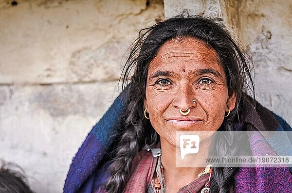 Dolpo  Nepal  ca. Juni 2012: Schwarzhaarige Frau mit goldenen Piercings in der Nase und Ohrringen hat einen roten Punkt auf der Stirn und schöne braune Augen in Dolpo  Nepal. Dokumentarischer Leitartikel  Asien