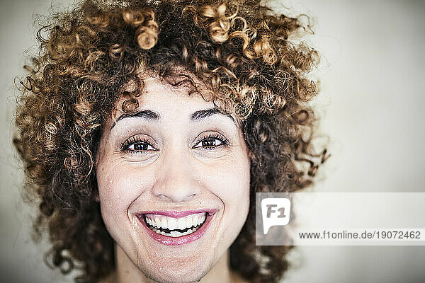 Portrait of sweating laughing woman with curly hair