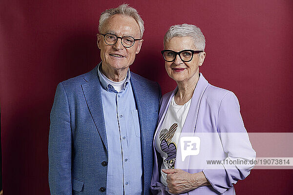 Portrait of senior couple against purple background