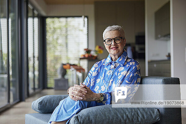Portrait of senior woman sitting on couch at home