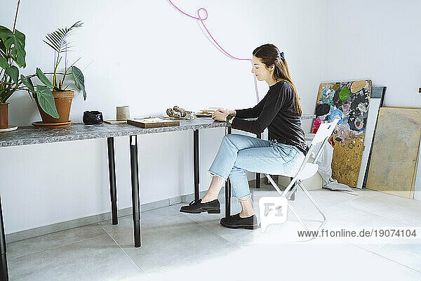 Artist sitting on chair working at workshop