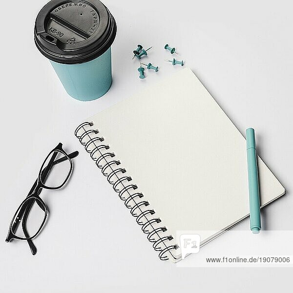 Einweg Kaffeetasse Stift Brille Spirale Notizblock Thumbtack Pins weißem Hintergrund