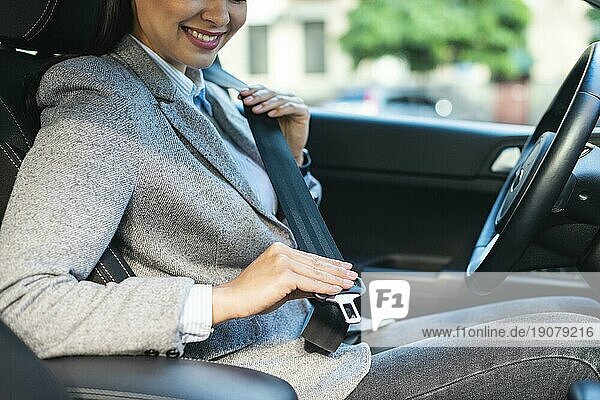 Seitenansicht smiley Geschäftsfrau setzen Sicherheitsgurt Auto