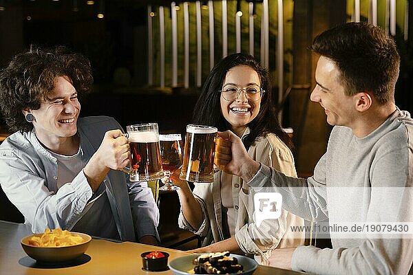 Mittlere Einstellung Freunde halten Bierkrüge
