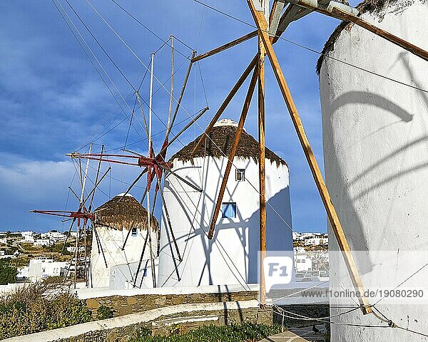Berühmte Touristenattraktion von Mykonos  Kykladen  Griechenland. Drei traditionelle  weiß getünchte Windmühlen am Wasser und in der Stadt Chora. Sommer  blauer Himmel  schöne Wolken. Reiseziel  ikonische Ansicht. Diagonale Zusammensetzung