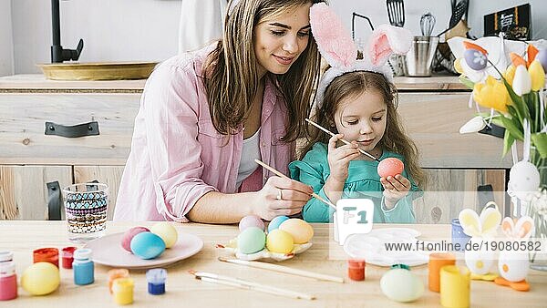 Kleines Mädchen Mutter Malerei Eier Ostern