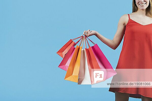 Mädchen mit Einkaufstaschen einfarbigen Hintergrund