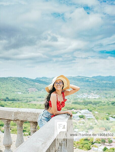 Glückliche Touristin mit Hut auf einem Aussichtspunkt. Porträt von Urlauber Mädchen in einem Aussichtspunkt. Reisen und Tourismus Förderung Konzept