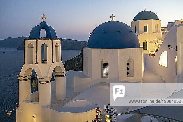 Zwei Kirchen mit blauen Kuppeln  Agios Spiridonas (St. Spyridon) und Kirche des Anastasis  Auferstehung  bei Einbruch der Dunkelheit  Ia  Oia  Santorin  Griechenland  Europa