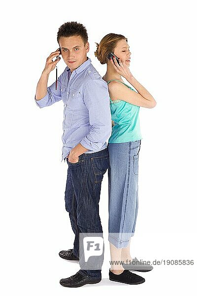 Junges attraktives lässiges Paar  das Rücken an Rücken steht und telefoniert  vor weißem Hintergrund