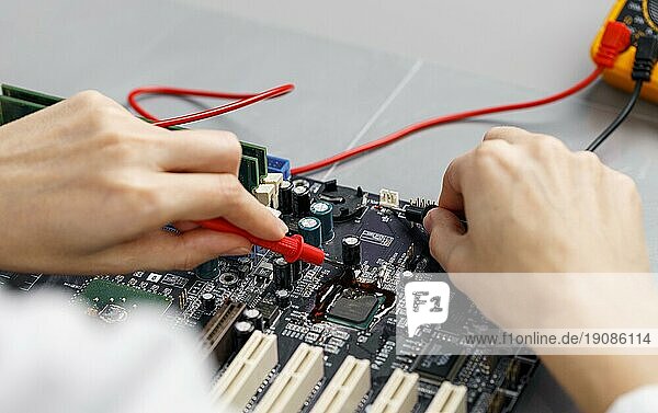 Technikerin mit hohem Winkel bei der Reparatur einer Computerhauptplatine
