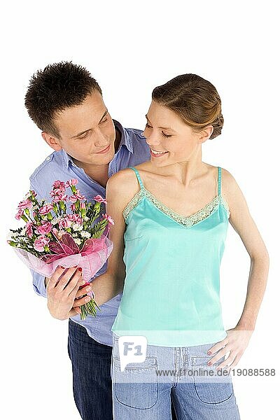 Glückliches  junges  attraktives  verliebtes Paar  Mann schenkt einer Frau Blumen  vor weißem Hintergrund