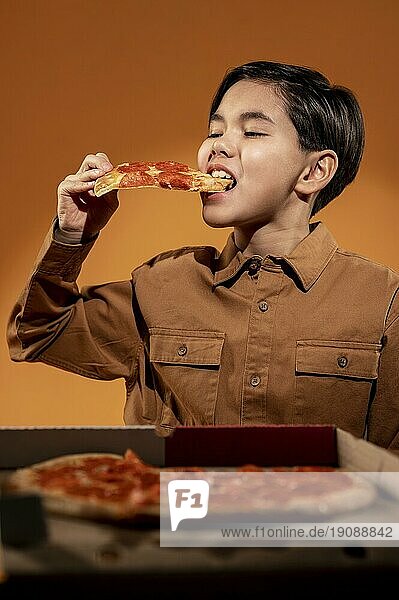 Mittlere Aufnahme Kind ißt Pizza