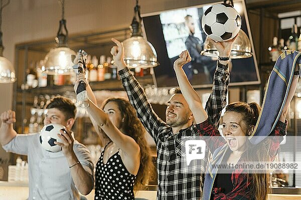 Gruppe von Freunden  die gemeinsam Sport schauen und den Sieg feiern Bar