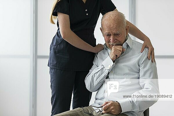 Krankenschwester tröstet alten weinenden Mann