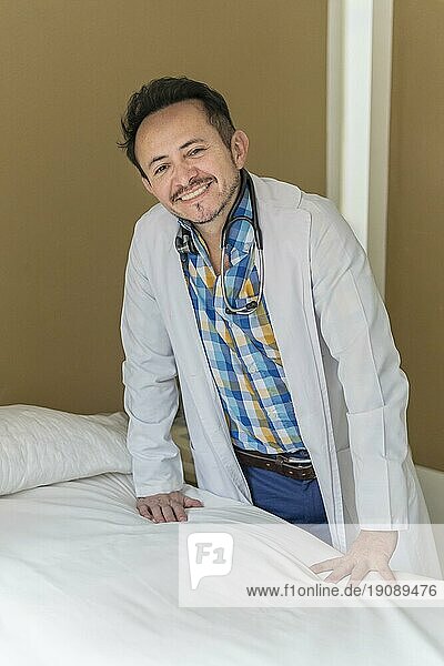 Latino Arzt posiert neben einem Tisch in seinem Schönheitszentrum