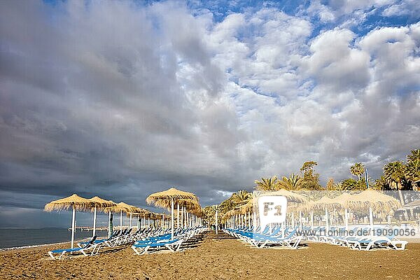Sonnenliegen am Morgen an einem Sandstrand am Mittelmeer im beliebten Ferienort Marbella  Costa del Sol  Andalusien  Spanien  Europa