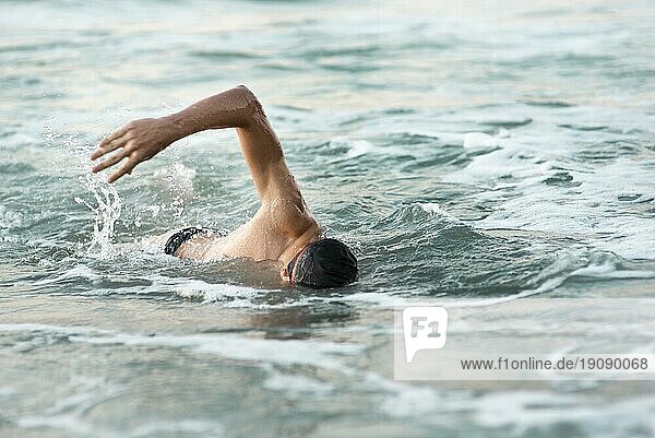 Männlicher Schwimmer schwimmt im Meer