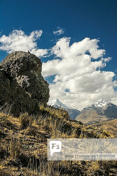 Foto eines großen Felsens mit der Bergkette Cordillera Negra in der Ferne in Peru  Südamerika