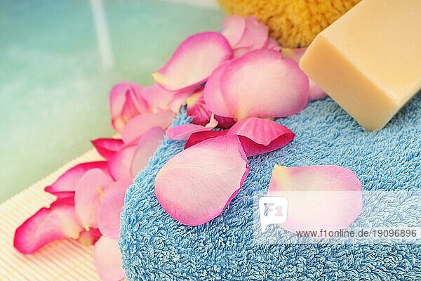 Handtuch  Rosenblätter  Seife und Schwamm vor einlaufenden Badewasser