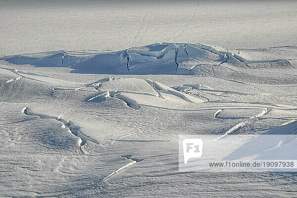 Sonnenbeschienene Risse im dichten Schnee bei Trolltunga  Norwegen  Europa