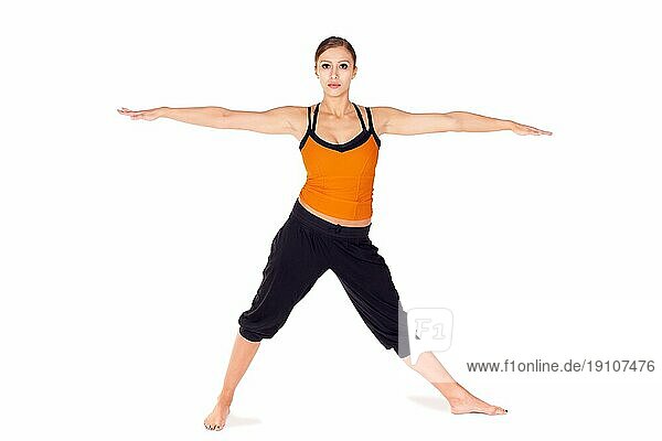 Fit attraktive junge Frau  die erste Stufe des Yogapose Warrior 2  vor weißem Hintergrund