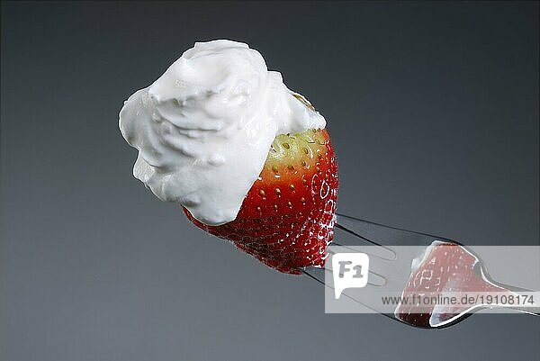 Erdbeere mit Sahne auf einer Gabel. Strawberry with cream