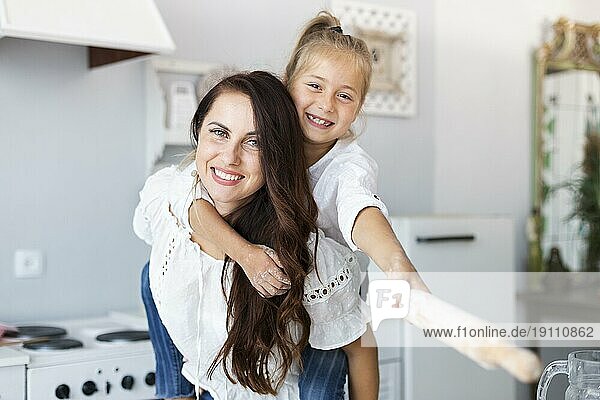 Glückliche Mutter Tochter posiert mit Küchenrolle