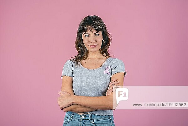 Seriöse Frau mit rosa Brustkrebsschleife