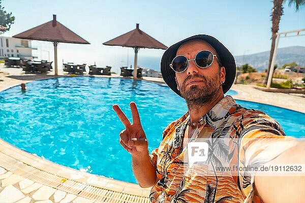 Tourist Mann im Hotelpool im Sommer ein Selfie genießen den Urlaub nehmen
